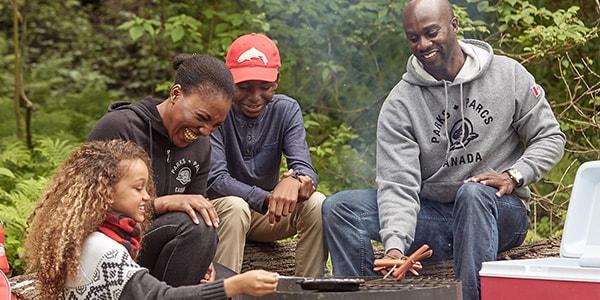 A family gathers around the campfire.